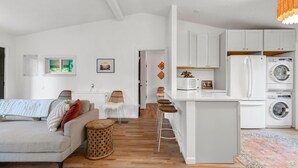 Un apartamento moderno con sala de estar, cocina y un pequeño comedor.