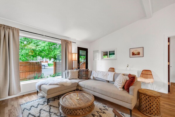 A modern living room with a sectional sofa, a round coffee table, and a small side table.