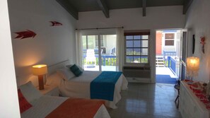 Une chambre d’hôtel avec deux lits, un balcon et une vue sur l’extérieur.