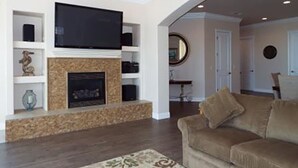 A living room with a fireplace, television, and a sofa. - Incredible Ocean Views 3 Bedrooms 3 Bathrooms (Trinidad)