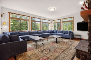 A spacious living room with a large sectional sofa, a coffee table, and a patterned rug.