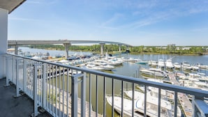 A balcony with a view of a marina and a bridge.