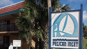 A sign for Pelican Inlet with a no trespassing notice and a drive safely sign.