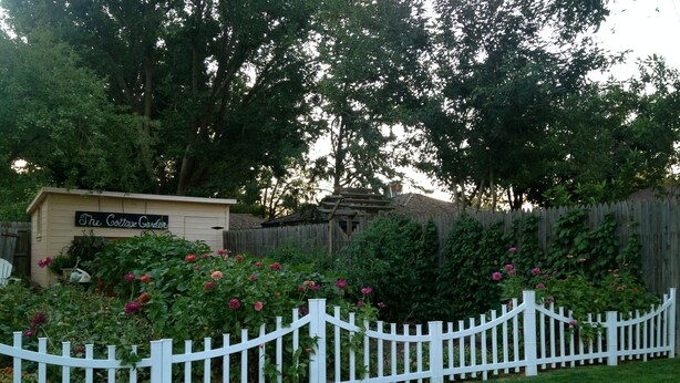 A fenced garden area with a sign reading "The Cottage Garden."