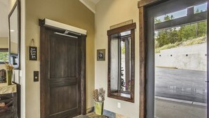 Un couloir avec une grande porte en bois, une petite fenêtre et une porte sur laquelle est affiché un panneau indiquant : « Ici, les amis se réunissent ».