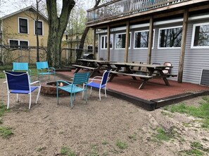 An outdoor seating area with metal chairs and a picnic table, surrounded by a brick patio. - Lake Access Retreat Pet Friendly Fire Pit (Geneva)