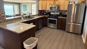A modern kitchen with granite countertops, stainless steel appliances, and wooden cabinets. - Lake Access Retreat  Pet Friendly  Fire Pit (Geneva)