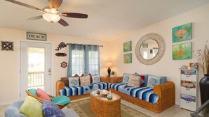 A beach-themed living room with a sofa, armchairs, and a coffee table.