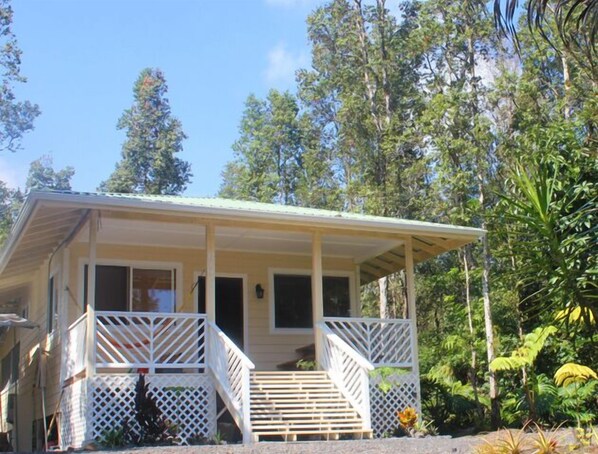 A single-story house with a covered porch and a staircase leading to the entrance. - Off-Grid Glamping Close to Beaches (Pahoa)