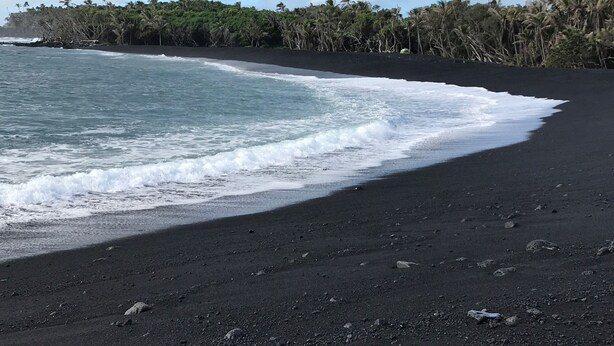 Una platja amb sorra negra i onades.
