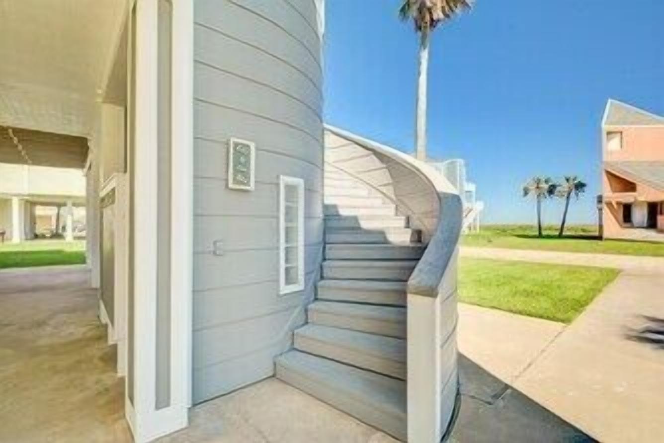 A corner of a building with a curved staircase leading to a landing.