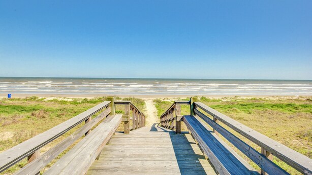 A wooden boardwalk leading to a beach with a clear view of the ocean. - Lei by the Sea, Beautiful 2nd Row Beach House with Elevator (Galveston)