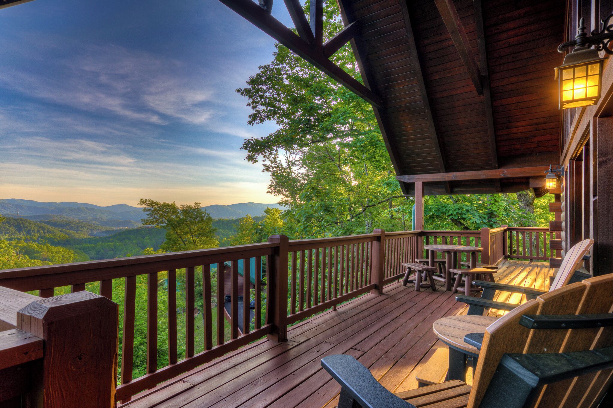 Une terrasse en bois avec des sièges extérieurs et une vue sur les montagnes.
