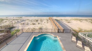 A pool area with a view of the beach and ocean.