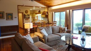 A cozy living room with a wooden ceiling, a dining area with chairs, and a large window offering a view of greenery. - Stunning Views, close to Wineries, Primland & Parkway - beautifully appointed (Meadows of Dan)