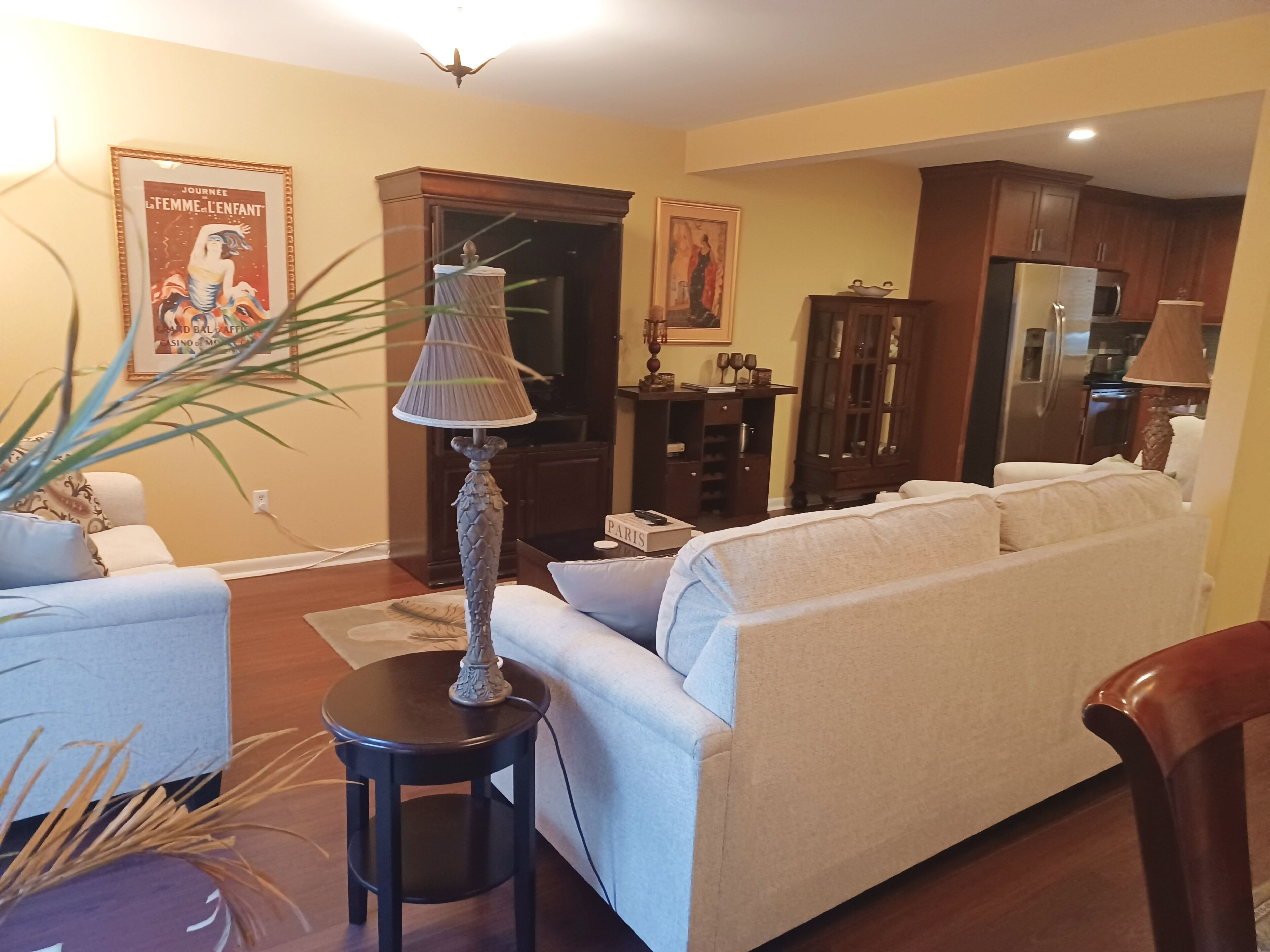A living room with a sofa, a lamp, a cabinet, and a painting on the wall.