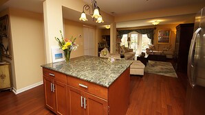 A spacious kitchen with wooden cabinets, a granite countertop, and a central island. - Beautiful Townhome 10 min from Charleston & Beaches, Pool, Tennis Court! (Charleston)