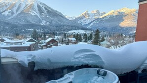 Ett bubbelbad med ett snötäckt landskap och berg i bakgrunden.