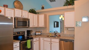 A modern kitchen with stainless steel appliances, white cabinets, and a granite countertop. - Orlando Villa near Disney, free Private Heated Pool, free Grill and free WiFi (Davenport)