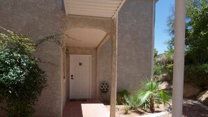 A covered outdoor area with a concrete pathway leading to a door marked with the number 05.