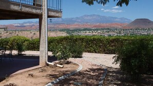 A balcony with a view of a desert town and mountains.