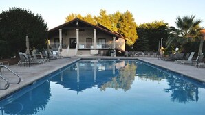 A swimming pool with lounge chairs and a building in the background.