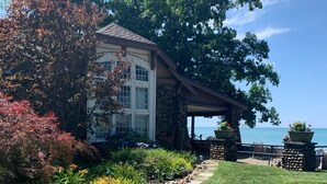 A house with a stone facade, a covered porch, and a view of the ocean. - Beachfront Historic home 2br/1Ba apt. w/  Steam Shower, WiFi, Netflix, Disney+  (Dunkirk)