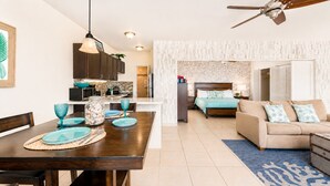 Un espai de vida modern amb zona de menjador, cuina i dormitori.