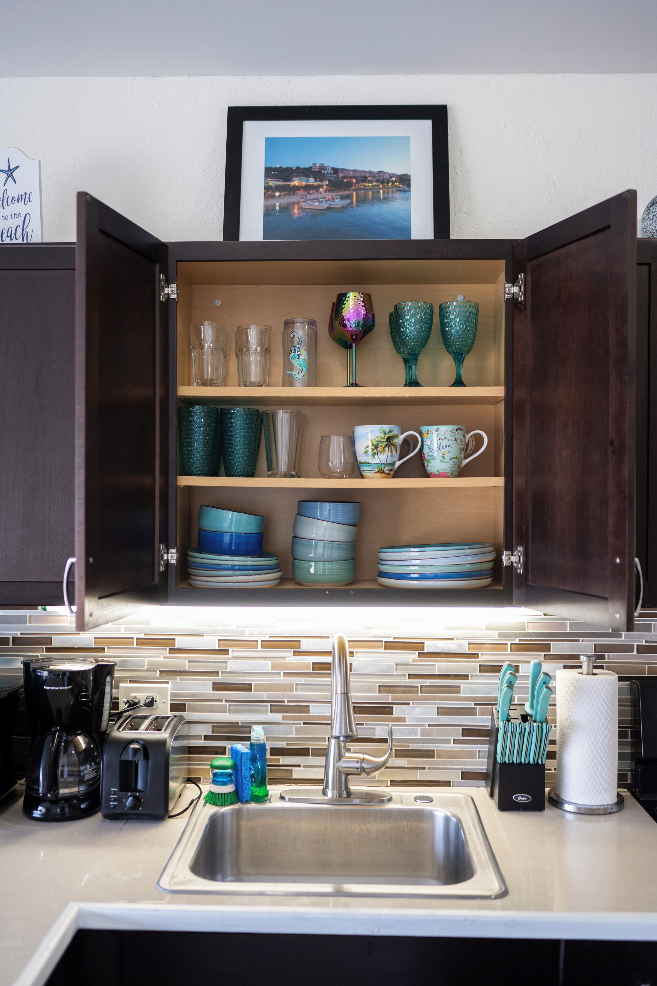 Una cocina con un armario empotrado que contiene varios vasos y platos.