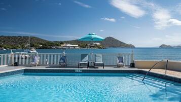 Una piscina con vista al mar y una isla distante.