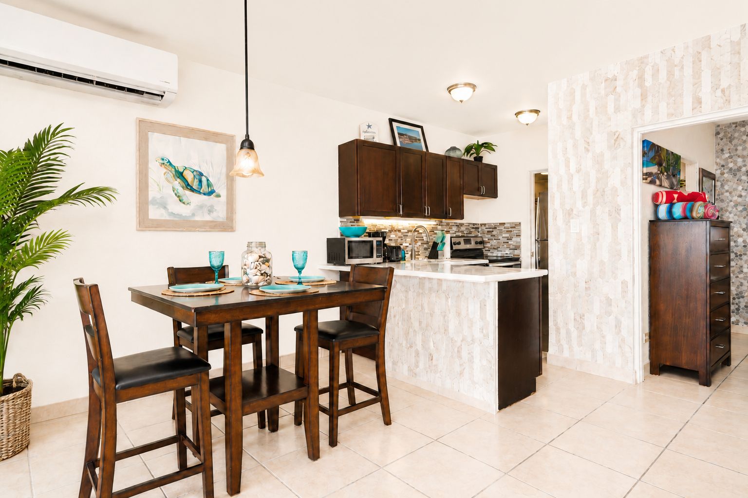 A modern kitchen with dark wooden cabinets, a central island, and a dining area with a table and chairs.
