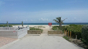 Une entrée de plage avec un panneau indiquant qu’il s’agit d’une propriété privée et que l’accès au public y est interdit.