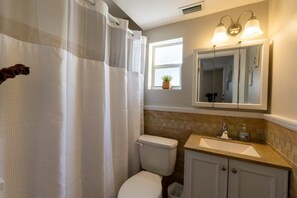 Une salle de bain avec des toilettes, un lavabo et un miroir.