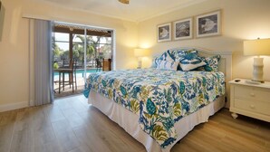 A bedroom with a bed, a nightstand, a ceiling fan, and a view of a pool through a sliding door.
