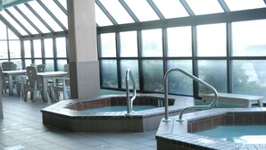 Un área de spa con dos jacuzzis y un espacio de descanso con sillas y mesas.