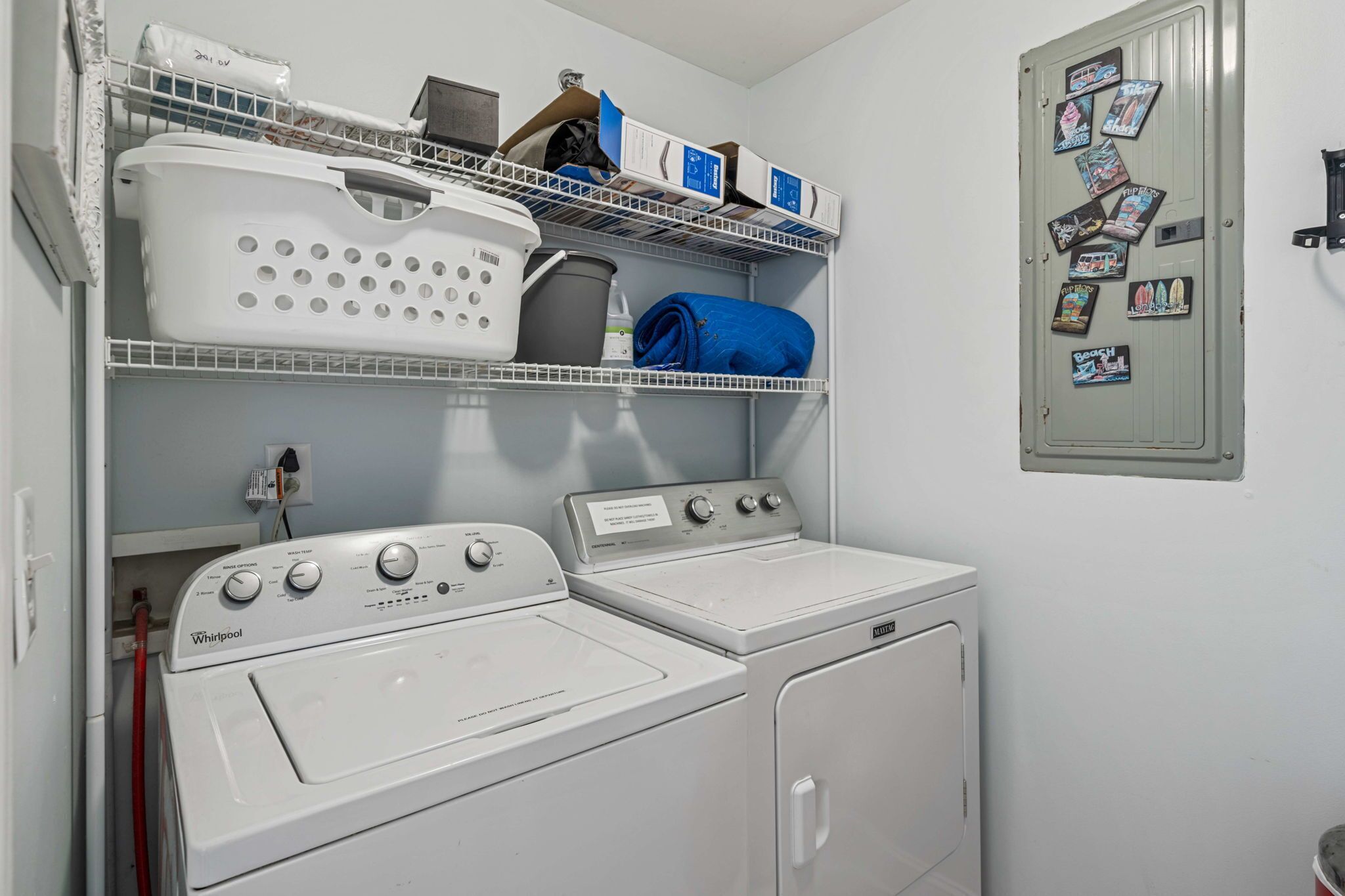 A laundry room with stacked laundry baskets, a washing machine, and a dryer.