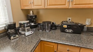 A kitchen with wooden cabinets, a coffee maker, a toaster, and various kitchen appliances on a granite countertop. - Riverfront, Kayaks, Boat Dock, Games, Pool, Hot Tub, 10 Min To Dwntwn Nashville! (Nashville)