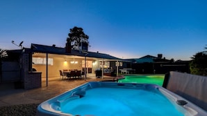A hot tub in a backyard with a covered patio area and a pool. - Close to Strip! Pool,  Spa,  Roulette Table,  Golf (Las Vegas)