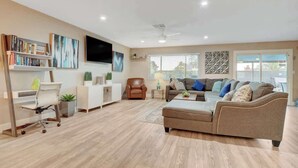 A modern living room with a sofa, armchair, and a flat-screen TV. - Close to Strip! Pool,  Spa,  Roulette Table,  Golf (Las Vegas)