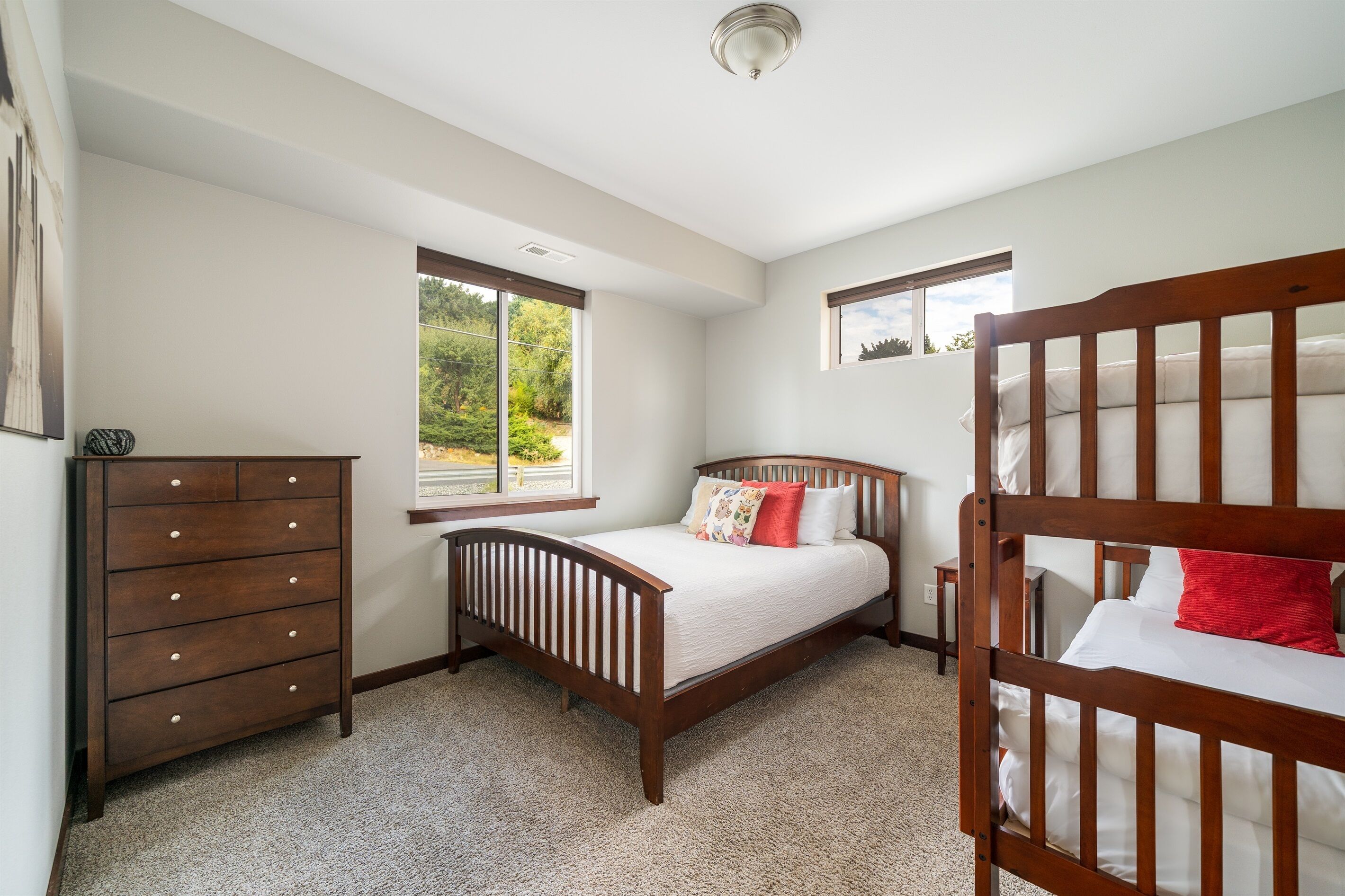 A bedroom with a wooden bed, a dresser, and a window.