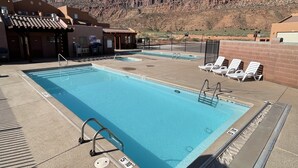 A rectangular pool with a clear blue water, surrounded by lounge chairs and a poolside area. - 8A6 Amazing Views, Shared Pool/Hot Tub, Private Patio and Garage (MOAB)