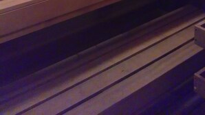En bastu med träbänkar och ett sluttande golv.