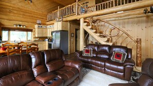 A wooden cabin interior with a living room, dining area, and a staircase. - Cpt Cook - Unique Alaskan log home in trees & wildflowers on 14-acre homestead. (Anchor Point)