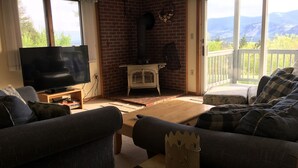 A cozy living room with a fireplace, a television, and a sofa. - Peaceful, Family Friendly, Heated Outdoor Pool, Awesome Views, Near Story Land (Bartlett)