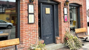 A brick building with a black door and a sign reading "Wathershed".