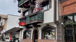 A building with multiple balconies, decorated with Christmas trees and snowflakes.