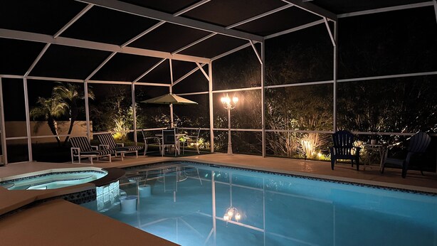 An indoor swimming pool with a covered area, lounge chairs, and a table. - Gorgeous, near parks, 2 master suites, private pool&spa, covered patio, wifi (Davenport)