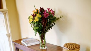 A wooden table with a vase of flowers, a book, and a decorative box.