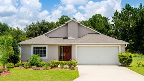 A single-story house with a garage, a front door, and a small porch area.