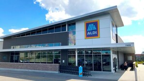 A modern building with a large windowed facade, a prominent ALDI logo, and a visible address number. - HUGE Pool Deck 15 mins to Disney! 360º Sun, Privacy-Games-Chef’s Kitchen + More! (Loughman)
